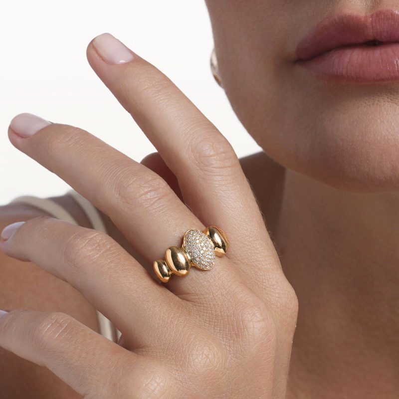 img src="bague.jpg" alt="bague en or rose avec motif ovale pavé de diamants blancs design moderne sur mannequin"