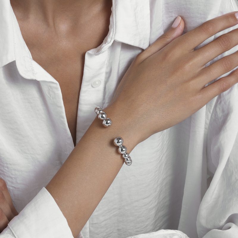 img src="bracelet.jpg" alt="bracelet jonc ouvert en or blanc avec perles sphériques design minimaliste sur mannequin"